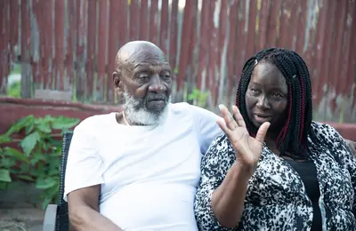 Elderly couple sitting together outdoors